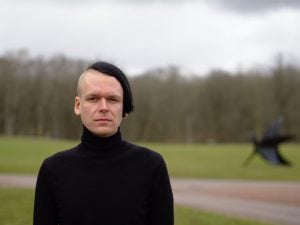 John Edström fotad framifrån. Gräsmatta utanför fokus i bakgrunden.