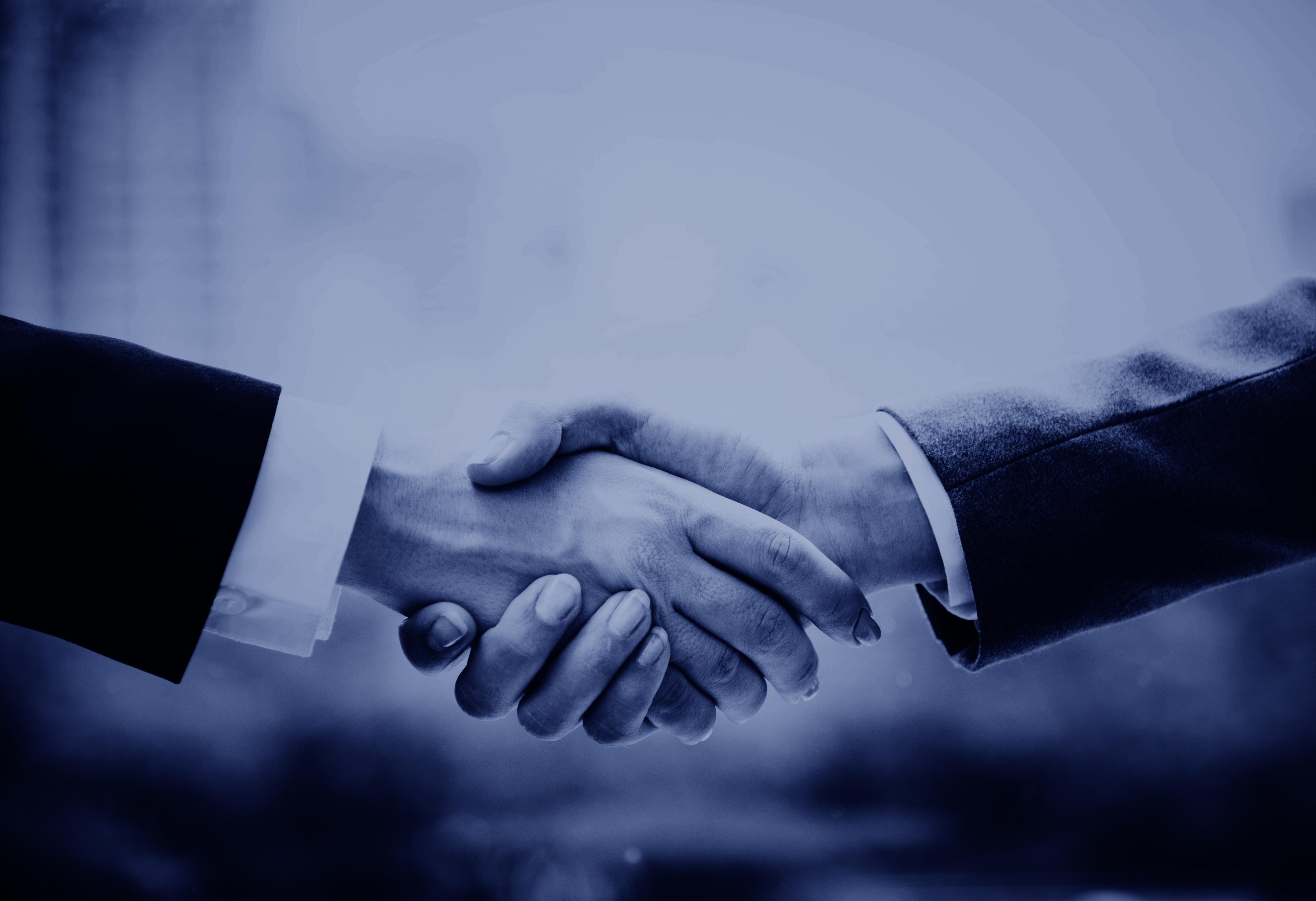 två personer i kostym skakar hand