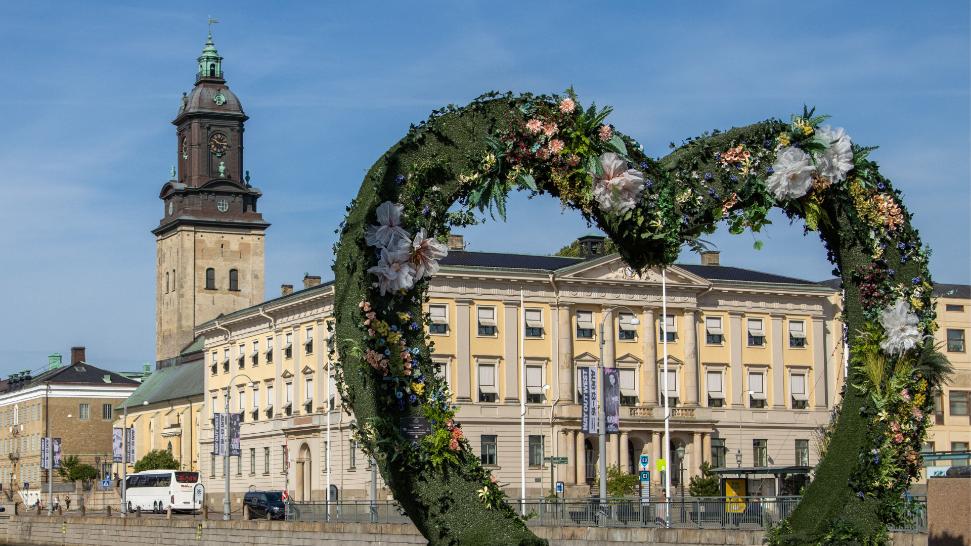Grönt hjärta klätt av växter med stadshuset i bakgrunden