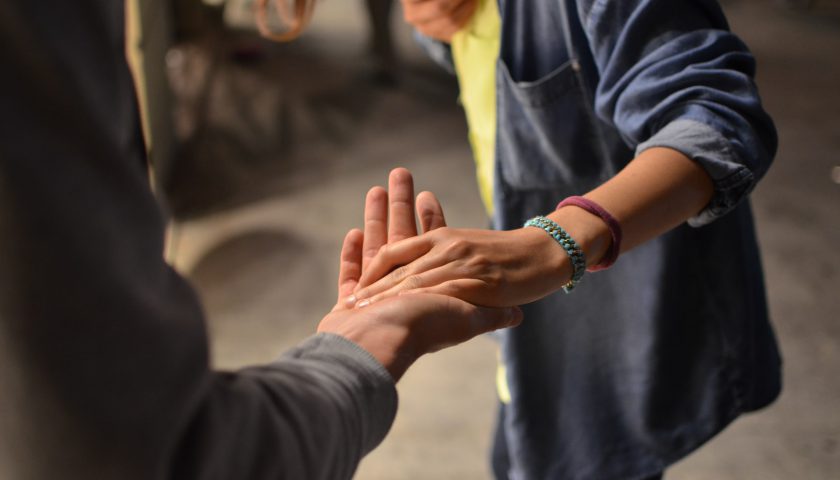 en person som lägger sin hand i en annan persons hand