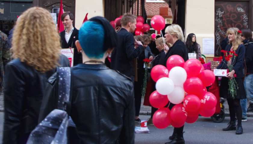 Entrén till Andra Långgatan 20. Fullt med folk utanför och ballonger syns.